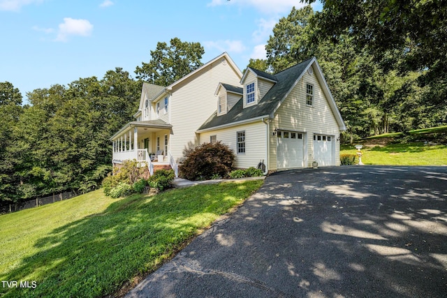 view of front of house featuring a front lawn, covered porch, and a garage