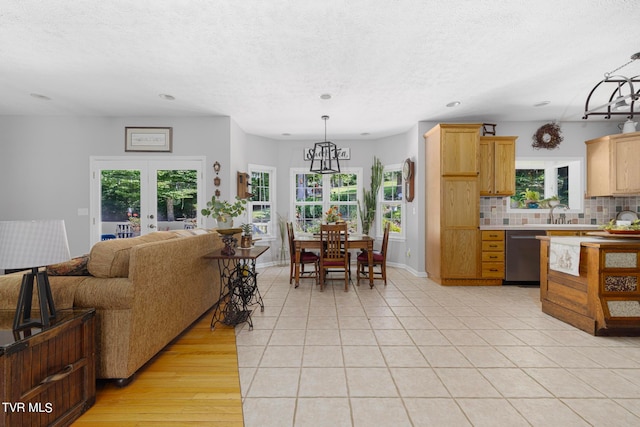 interior space featuring light wood-type flooring, french doors, and a healthy amount of sunlight