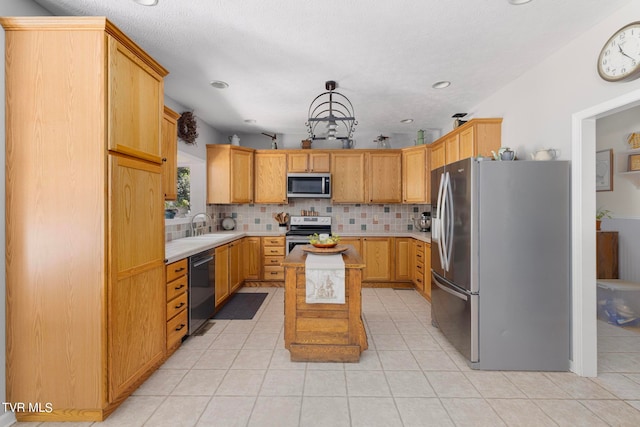 kitchen featuring stainless steel appliances, light tile patterned floors, decorative backsplash, sink, and a center island