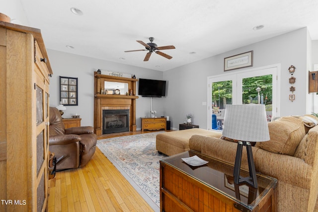 living room featuring ceiling fan, french doors, and light hardwood / wood-style floors