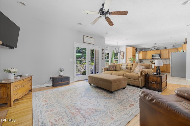 living room featuring ceiling fan and light hardwood / wood-style floors