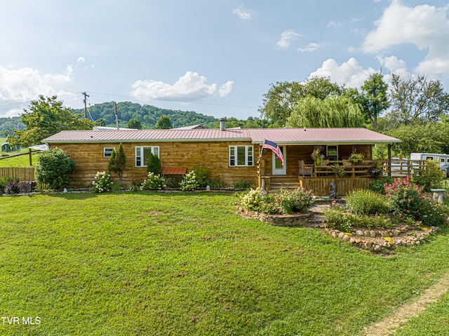 rear view of property with a yard and metal roof
