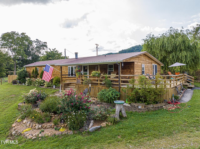 back of property featuring a lawn and metal roof