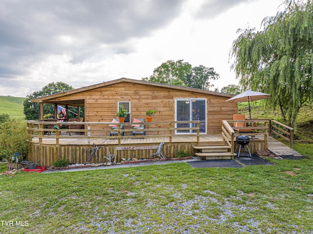 back of property with a wooden deck and a yard