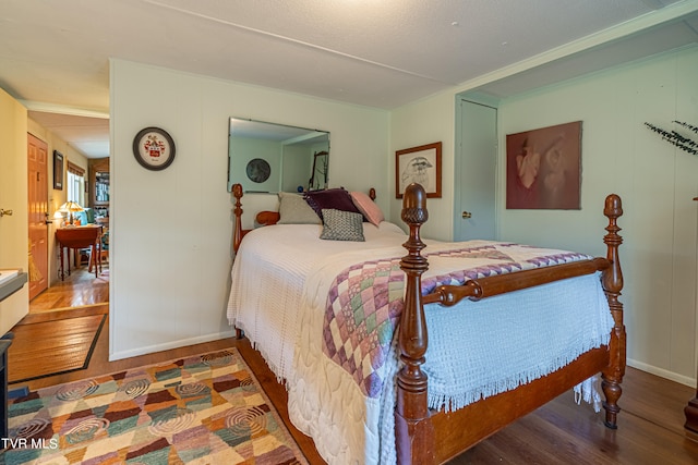 bedroom with baseboards and wood finished floors