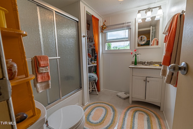 bathroom featuring tile patterned flooring, vanity, toilet, a textured ceiling, and enclosed tub / shower combo