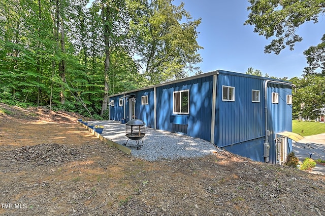 view of property exterior with an outdoor fire pit