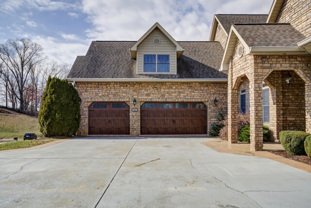 450 Lake Approach, Johnson City, TN 37601 - view of front facade featuring stone siding, concrete driveway, an attached garage, and a shingled roof
