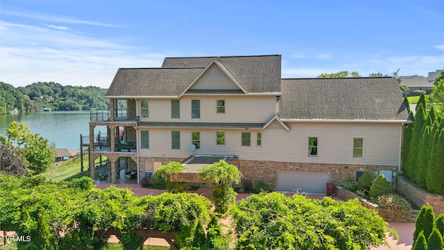 back of property featuring a balcony and a water view