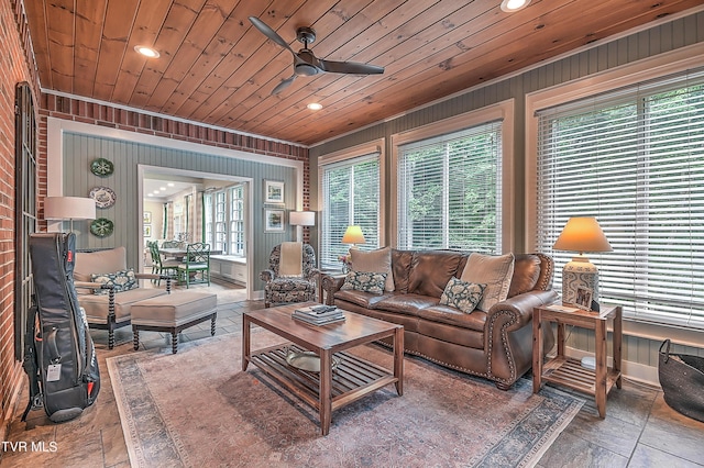 living room with wooden walls, wooden ceiling, and ceiling fan