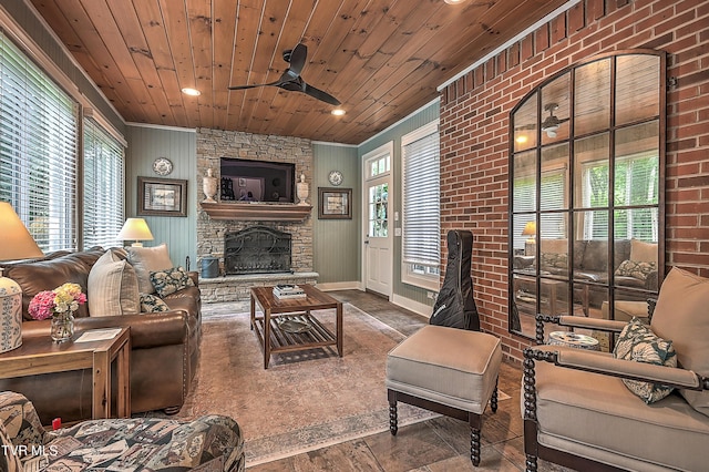 living room featuring wood ceiling, plenty of natural light, and a stone fireplace