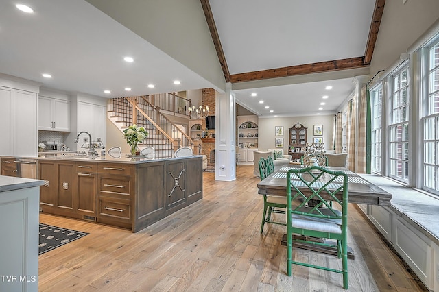 kitchen featuring sink, a kitchen island with sink, and light hardwood / wood-style flooring