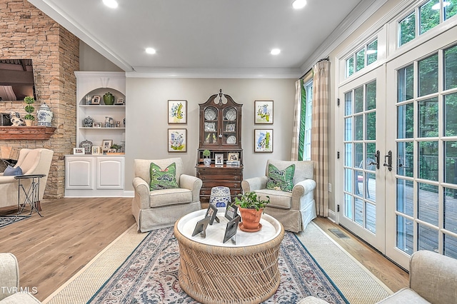 sitting room with french doors, ornamental molding, and light hardwood / wood-style flooring