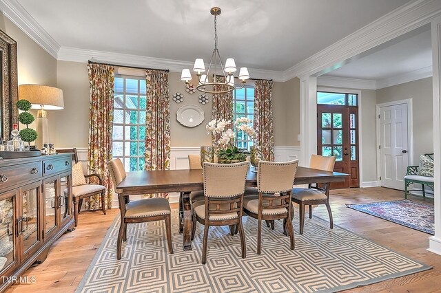 dining space with light hardwood / wood-style flooring, plenty of natural light, and ornamental molding