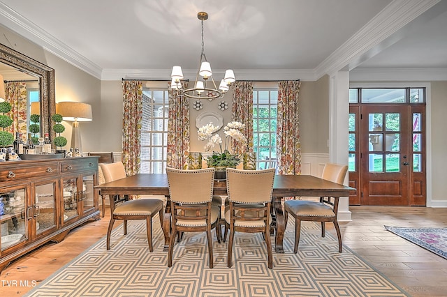 dining space featuring ornamental molding, a notable chandelier, and light hardwood / wood-style floors