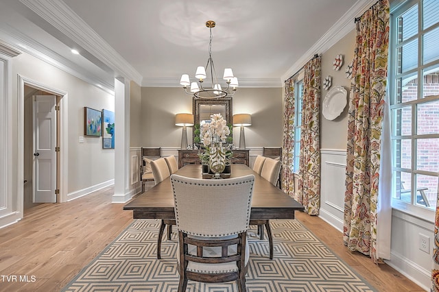 dining area with ornamental molding, a chandelier, and light wood-type flooring