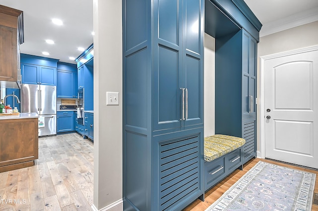 mudroom featuring ornamental molding, sink, and light hardwood / wood-style flooring