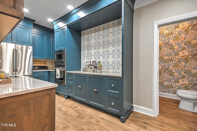 kitchen featuring stainless steel appliances, blue cabinets, and light hardwood / wood-style floors