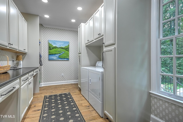 washroom featuring cabinets, independent washer and dryer, and light hardwood / wood-style floors