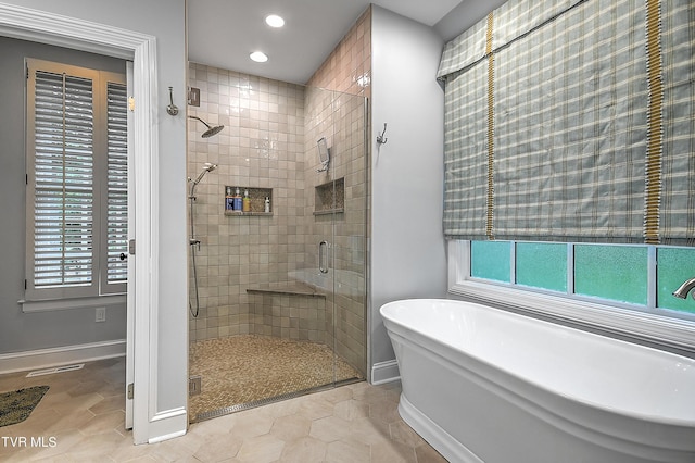 bathroom featuring tile patterned floors and independent shower and bath