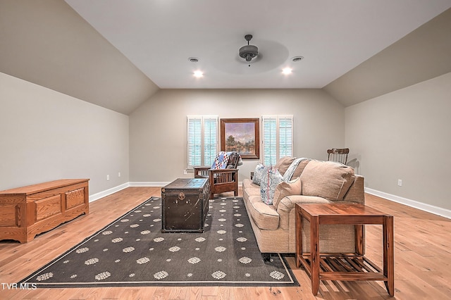 living room with lofted ceiling, ceiling fan, and light hardwood / wood-style flooring