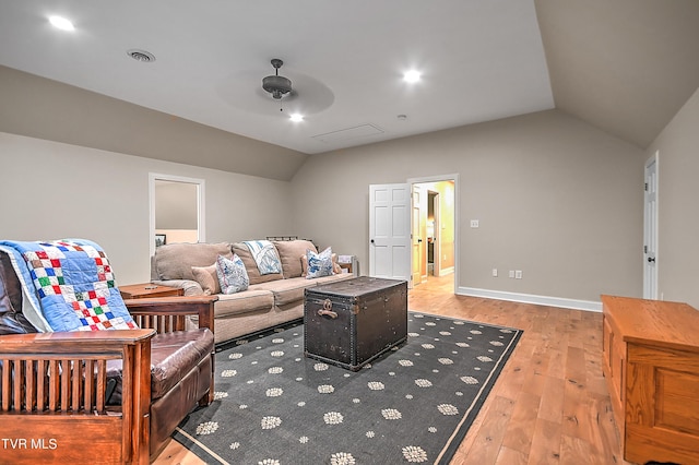 living room with ceiling fan, light hardwood / wood-style floors, and vaulted ceiling