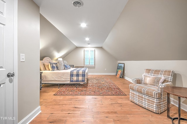 bedroom with vaulted ceiling and light wood-type flooring