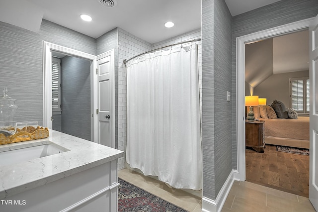 bathroom with tile patterned flooring, vanity, and walk in shower