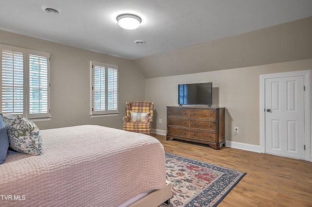 bedroom with hardwood / wood-style flooring and vaulted ceiling