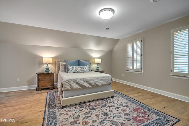 bedroom with hardwood / wood-style floors and vaulted ceiling