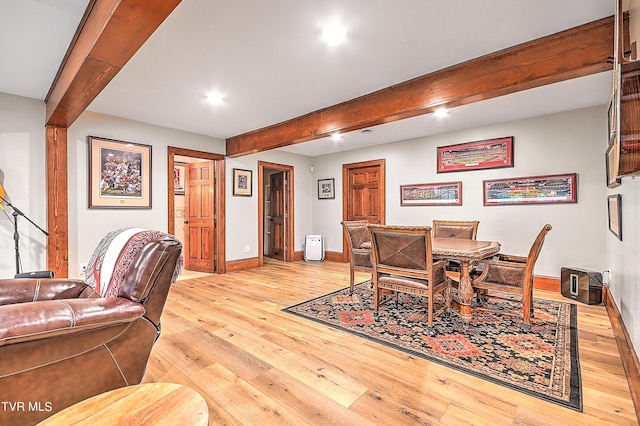 dining room featuring beamed ceiling and light wood-type flooring