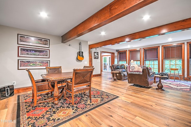 dining room featuring heating unit, light hardwood / wood-style flooring, and beamed ceiling