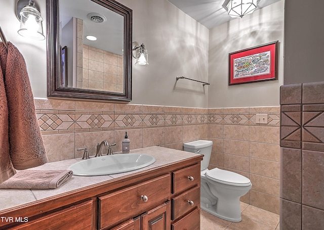 bathroom featuring vanity, tile walls, tile patterned floors, and toilet