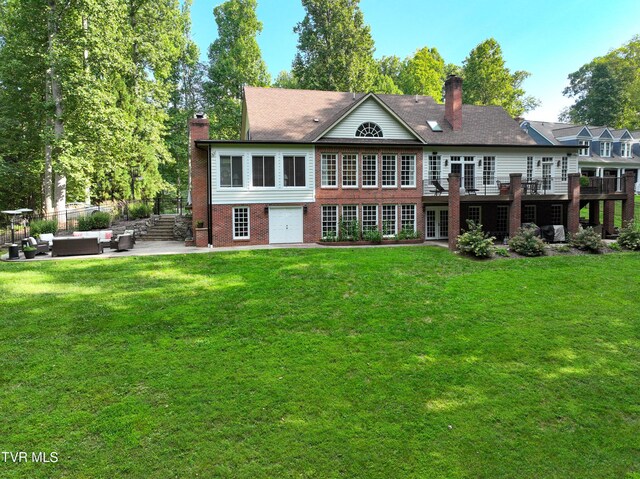 back of house featuring a patio, outdoor lounge area, a deck, and a lawn