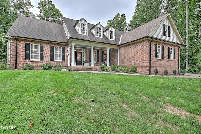 cape cod home with covered porch and a front yard