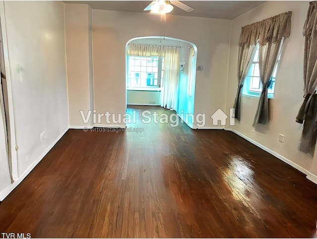 empty room featuring ceiling fan, plenty of natural light, and dark hardwood / wood-style floors