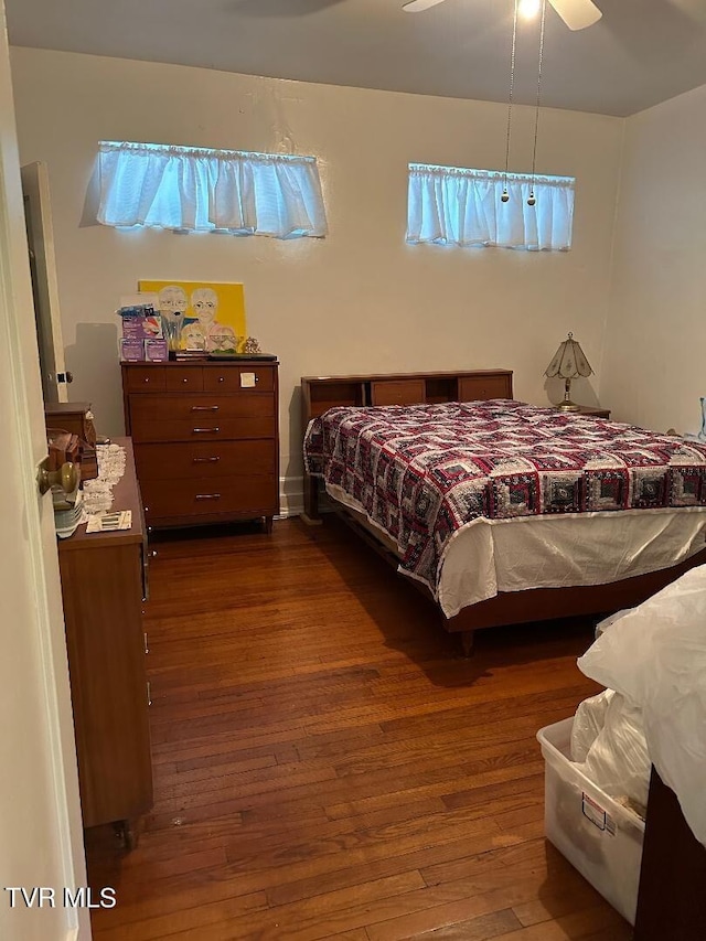 bedroom with ceiling fan and dark hardwood / wood-style flooring