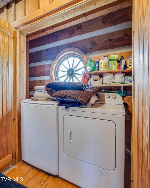 2390 W Allens Bridge Rd, Greeneville, TN 37743 - washroom with washing machine and clothes dryer, wooden walls, and light wood-type flooring