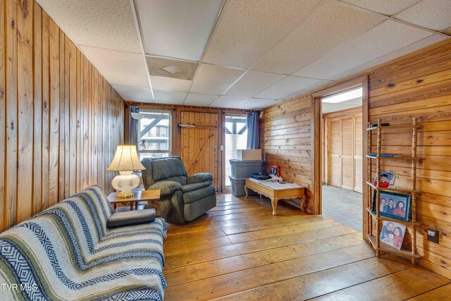 2390 W Allens Bridge Rd, Greeneville, TN 37743 - living room featuring wood walls, light wood-style floors, a drop ceiling, and a wood stove