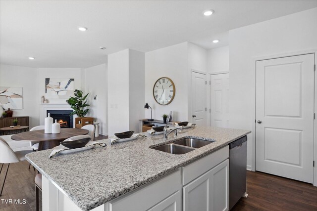 kitchen featuring dishwasher, dark hardwood / wood-style floors, a center island with sink, and sink