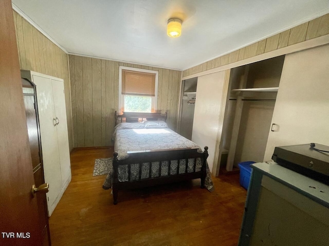 bedroom with wood walls, a closet, and dark wood-style flooring