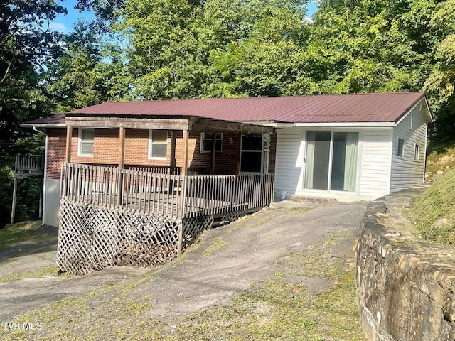 single story home with brick siding and metal roof