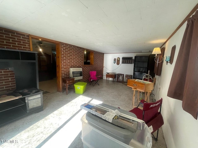 living room with a brick fireplace, brick wall, and heating unit