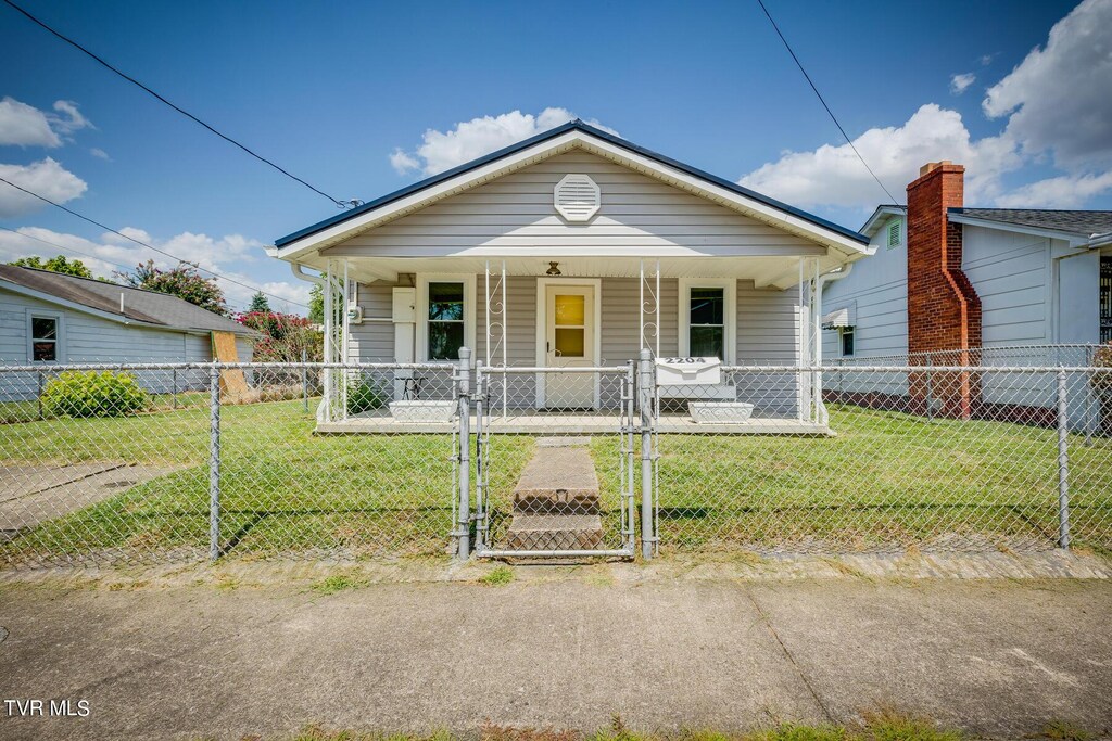 bungalow featuring covered porch and a front lawn