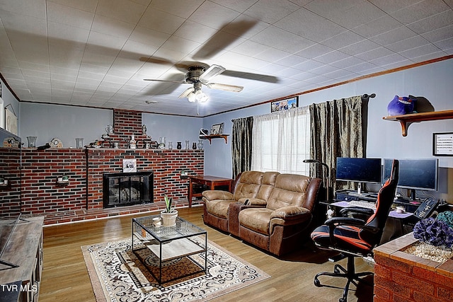 living area with a fireplace, wood finished floors, and ornamental molding