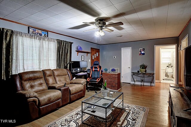 living room with ceiling fan, hardwood / wood-style flooring, and ornamental molding