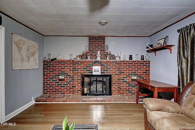 unfurnished living room featuring a brick fireplace, wood finished floors, visible vents, and ornamental molding