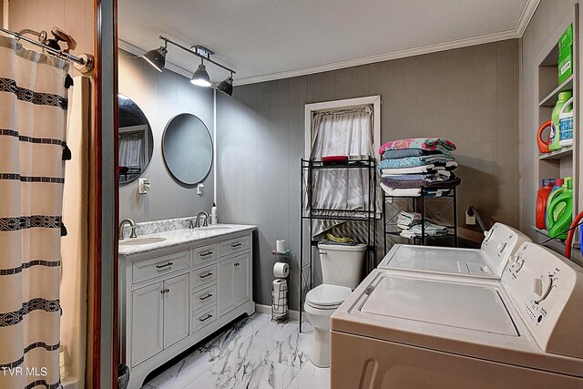 laundry area with sink, washing machine and clothes dryer, ornamental molding, and light tile patterned floors