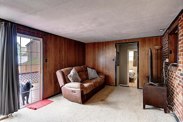 living room featuring visible vents, a textured ceiling, brick wall, and wooden walls