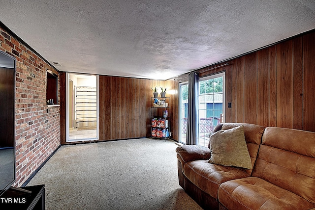 unfurnished living room featuring visible vents, wood walls, a textured ceiling, and carpet floors